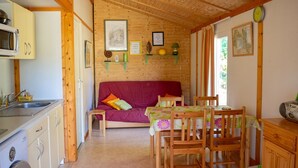 Interior acogedor de una cabaña con cocina, comedor y sofá.