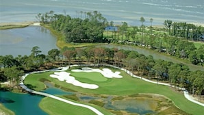 A golf course with sand bunkers, water hazards, and a clubhouse. - Sisters 3 by the Sea, 400 Feet To The Beach (Cape Charles)