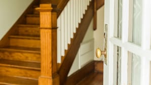 A wooden staircase with white railings and a door with a round knob. - Sisters 3 by the Sea, 400 Feet To The Beach (Cape Charles)