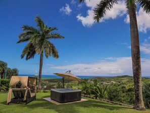 A hot tub, a covered seating area, and a view of the ocean. - Beautiful Home - Rooftop - Private Jacuzzi - Rainforest & Beach ☀ (Luquillo)