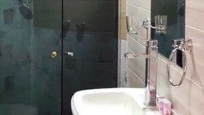 A bathroom with a glass shower enclosure, a white sink, and a mirror. - Portal Rent Apart 6 (Cochabamba)