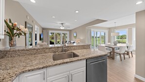 A modern kitchen with granite countertops, a stainless steel sink, and a dishwasher.