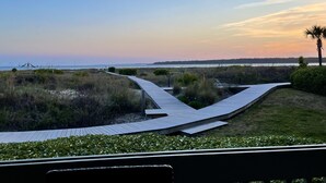 A wooden boardwalk leading to a beach with a view of the ocean and a sunset. - Beachfront 1BR/2BA Villa, Pet Friendly, Stunning Views, Amenity Access included (Seabrook Island)
