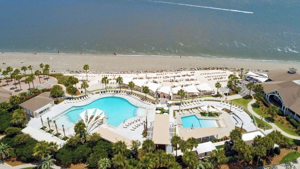 An aerial view of a resort with multiple swimming pools, a beach, and palm trees. - Beachfront 1BR/2BA Villa, Pet Friendly, Stunning Views, Amenity Access included (Seabrook Island)