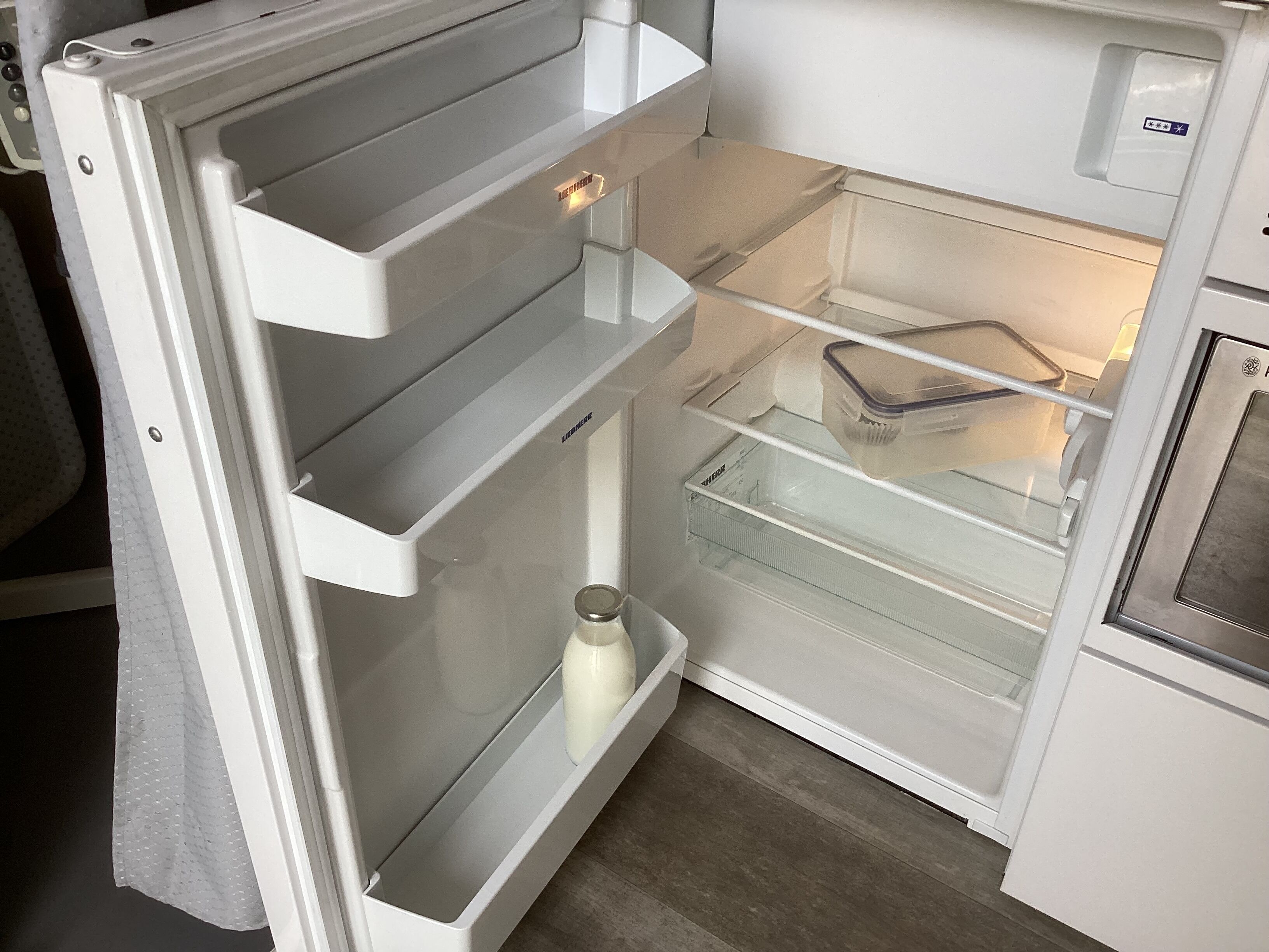 An open refrigerator with multiple shelves and a freezer compartment.