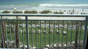 A beach view with a railing, beach chairs, and a clear sky. - 25 ft. Balcony Oceanfront ! Incredible views !MONTHLY WINTER RENTAL AVAILABLE ! (Myrtle Beach)