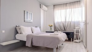 A modern bedroom with a bed, bedside table, and a small desk with a chair. - Acropolis front row loft,please watch video (Athens)