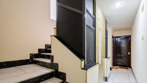 A staircase with black and white marble steps, a black handrail, and a door at the end.