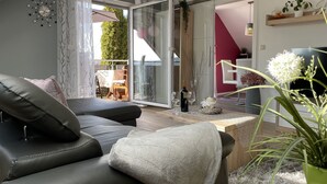 A modern living room with a sofa, a coffee table, and a view of the outside. - Modern apartment in Schauenstein with loggia and balcony **** (Schauenstein)