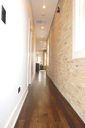 Stroll through this beautifully lit corridor with exposed brickwork and wooden floors.