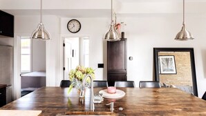 Una cocina moderna con una isla grande, luces colgantes y un reloj en la pared.