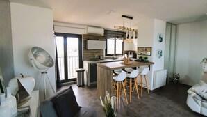 A modern kitchen with a central island, bar stools, and a dining area. - Apartment for 6 people, air-conditioned, with a view of the port at the Marines de Cogolin (COGOLIN)