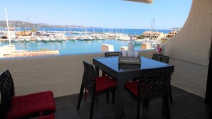 A terrace with a table and chairs, overlooking a marina with boats. - Apartment for 6 people, air-conditioned, with a view of the port at the Marines de Cogolin (COGOLIN)