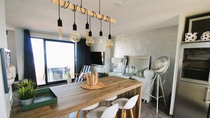A modern kitchen with a wooden island, white bar stools, and hanging light fixtures. - Apartment for 6 people, air-conditioned, with a view of the port at the Marines de Cogolin (COGOLIN)