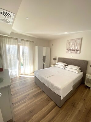 A bedroom with a large bed, a wardrobe, a desk, and a painting on the wall. - BaltimoreHouse. "Adults only" 4 apartments central with sea view and pool (Baška Voda)