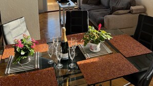A living room with a glass table set for dining, a sofa, and a balcony with a view. - FRANCE NICE PROMENADE OF ENGLISH 80 m2 PIANO    (Nice)