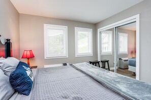 Un dormitorio con una cama, una mesita de noche, una lámpara y un espejo.