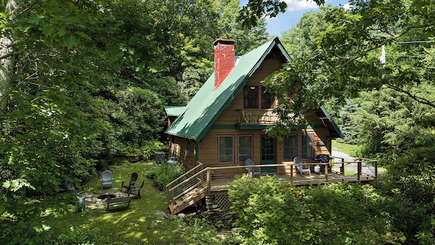 A cabin with a green roof, surrounded by dense forest. - Cabin near BR/Boone, fire pit, WIFI, secluded, nearby hikes, and VIEWS!! (Blowing Rock)