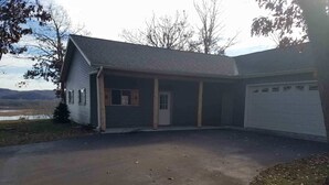 A single-story house with a covered porch, a garage, and a driveway leading to the front door. - Chippewa View Heights ~ breathtaking views and a peaceful getaway! (Durand)