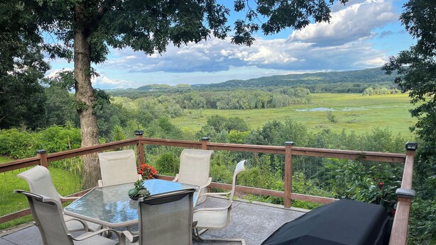 A deck with a table and chairs overlooking a scenic landscape. - Chippewa View Heights ~ breathtaking views and a peaceful getaway! (Durand)