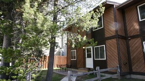 A two-story building with a wooden exterior and a small patio area with a table and chairs.