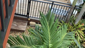 A balcony with a view of a pool area, including a wooden deck and a seating area with chairs and a table. - Venetian Shores Escape! Heated Pool, 3BR, 70ft Dock, Dog-Friendly! (Islamorada)