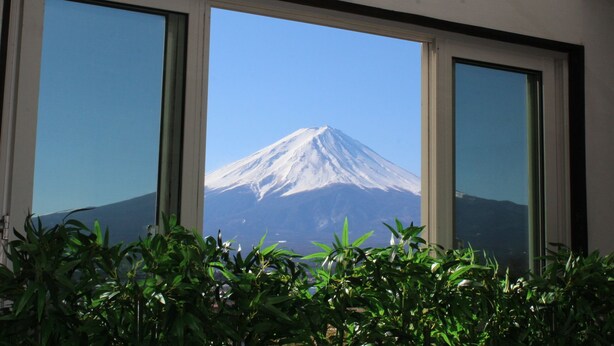 A room with a large window offering a view of a snow-capped mountain. - Fujikawaguchiko Crescendo (Fujikawaguchiko)