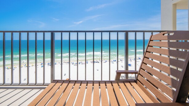 A balcony with a view of a beach and ocean.