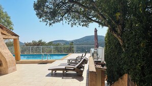 A poolside area with lounge chairs, a pool, and a view of mountains. - Villa 12 persons with heated swimming pool, sea view  (Saint-Raphaël)