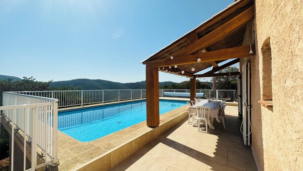 A swimming pool with a pergola and outdoor seating area, surrounded by a white fence and a view of hills. - Villa 12 persons with heated swimming pool, sea view  (Saint-Raphaël)
