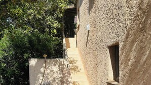 A tiled pathway leading to a building with a textured wall and a small window. - Villa 12 persons with heated swimming pool, sea view  (Saint-Raphaël)