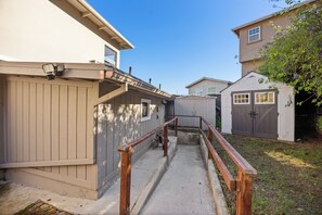 A residential area with a wooden fence, a concrete pathway, and a small shed. - Sparkling Clean Luxury Suite near SF/SFO/BART/CalTrain + EV + Free Parking +WiFi (South San Francisco)