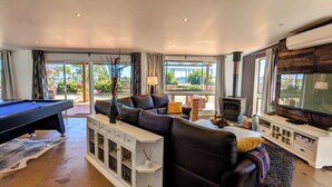 A modern living room with a pool table, a sofa, a television, and a fireplace. - Abercrombie Ridge - Lux BARN and Spa Retreat - Pet-friendly (Curraweela)