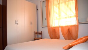 A bedroom with a bed, a chair, and a wardrobe. - Mediterranean villa - 150 meters from the promenade of Cefalu (Campofelice di Roccella (Pa))