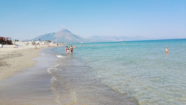 A beach with clear waters, a mountain in the background, and people enjoying the shore. - Mediterranean villa - 150 meters from the promenade of Cefalu (Campofelice di Roccella (Pa))