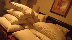 Una cama con varias almohadas y una colcha de estampado floral.