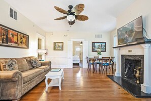 Un salon comprenant un canapé, une table basse, une cheminée et un ventilateur de plafond.