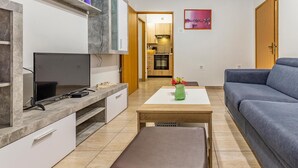 A compact living space with a TV, a small dining table, a sofa, and a kitchenette. - Beautiful apartment in Pula with WiFi (Pula)