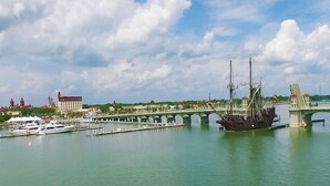Un río con un puente, barcos y edificios al fondo.