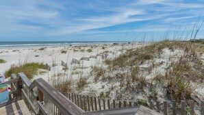 Una playa con un paseo marítimo de madera que llega hasta la orilla.