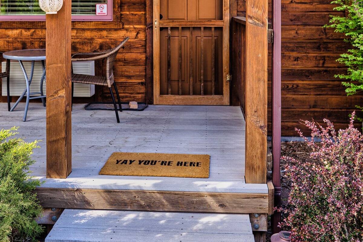 A wooden cabin with a porch, a door, and a sign that reads "CANYON".