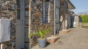 A stone building with a door labeled "3", a potted plant, and a paved walkway. - 🌿 Welcome to Tylney Retreat – Your Breathtaking Cornish Hideaway 🌿 (Edmonton)