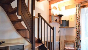 A staircase with wooden steps and a black handrail, leading to a room with a television on a shelf, a chair, and a desk with drawers. - Cozy House with Pool & Tennis, Near Beach, Sleeps 6 - Bormes-les-Mimosas (Bormes-les-Mimosas)