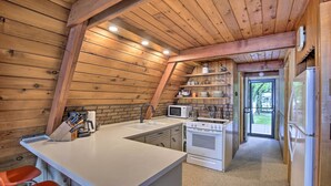 A kitchen with wooden walls, a white countertop, and a stove. - Lake Pepin Cottage w/ Decks + Private Beach! (Stockholm)