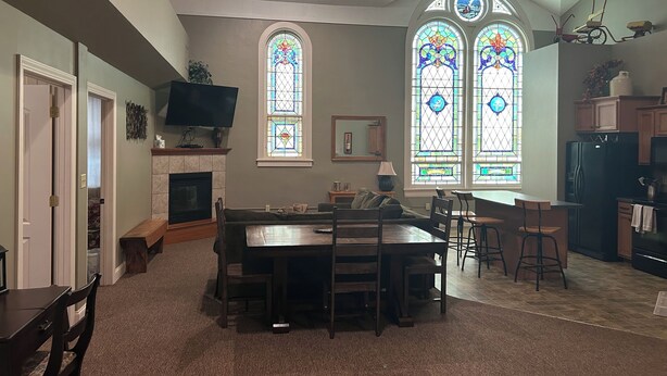 A spacious living room with a fireplace, a dining area, and a kitchen with wooden cabinets.