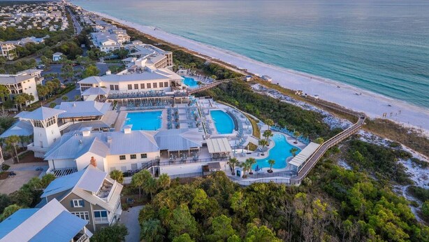 Un resort con varias piscinas, una playa y vistas al océano.