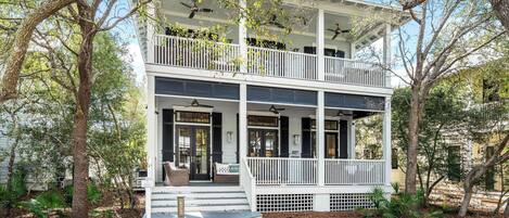 A two-story house with a balcony, a covered porch, and a front door.