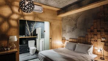 A modern bedroom with a wooden ceiling, a bed with white bedding, a nightstand with a lamp, and a wall-mounted heater.