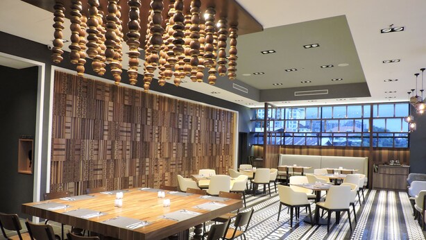 A modern conference room with a large wooden table, multiple chairs, and a patterned wall. - Hotel N°5 (Kota Kinabalu)