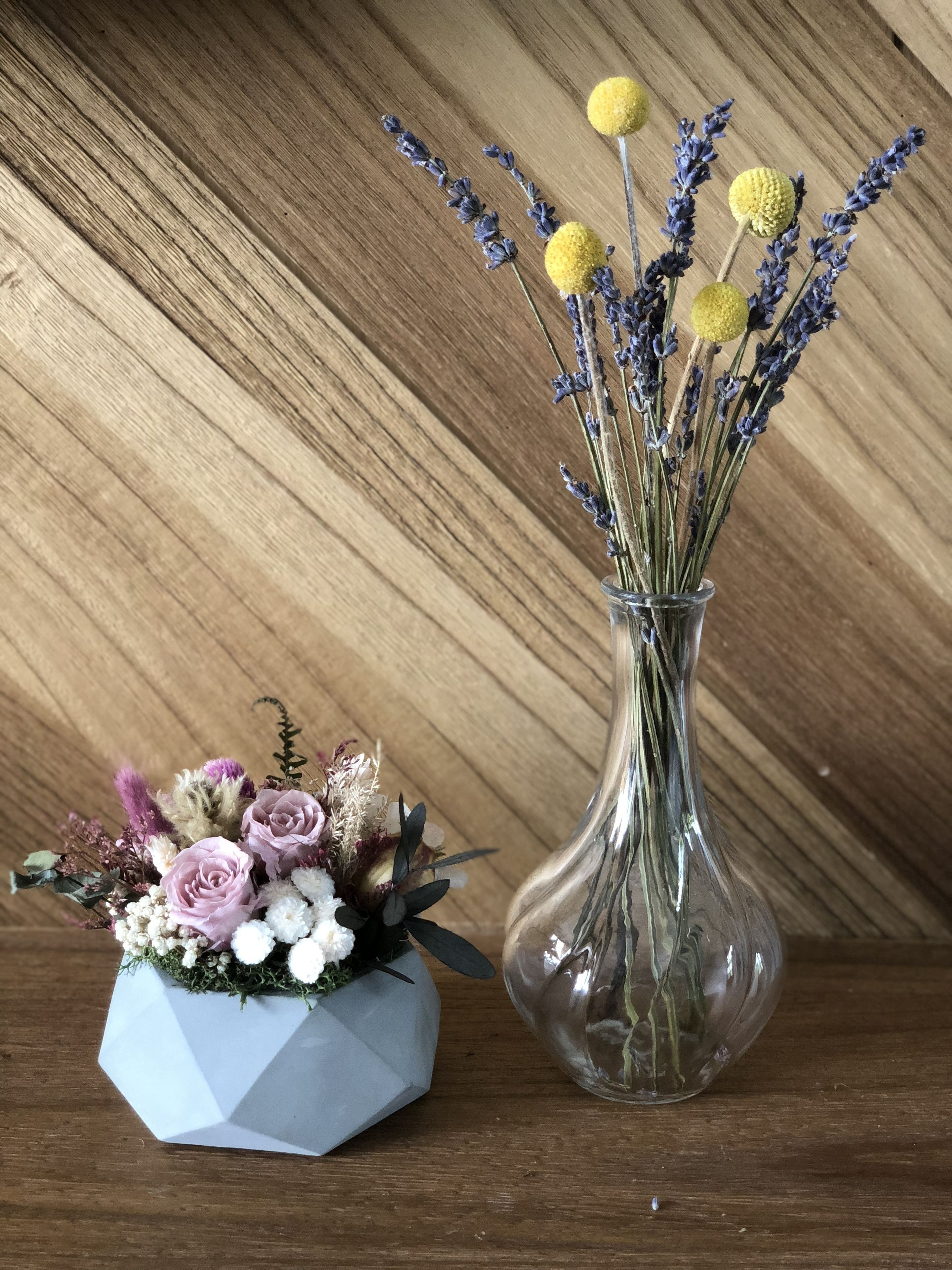 Dos jarrones con flores sobre una superficie de madera.